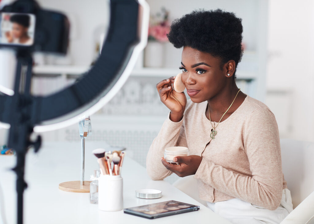 A creator filming a beauty tutorial with a ring light